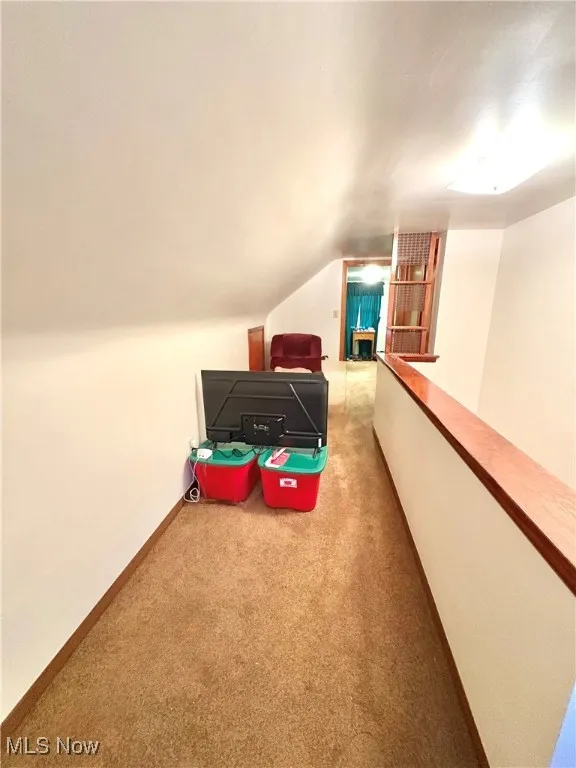 Carpeted bedroom with lofted ceiling and baseboards
