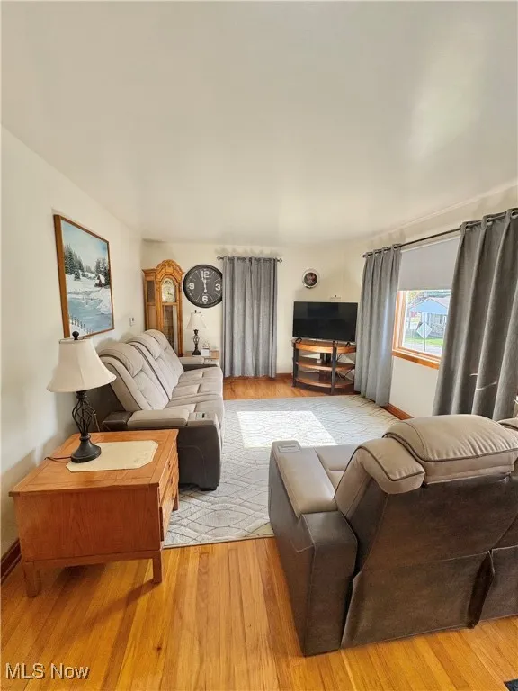 Living area with wood finished floors and baseboards