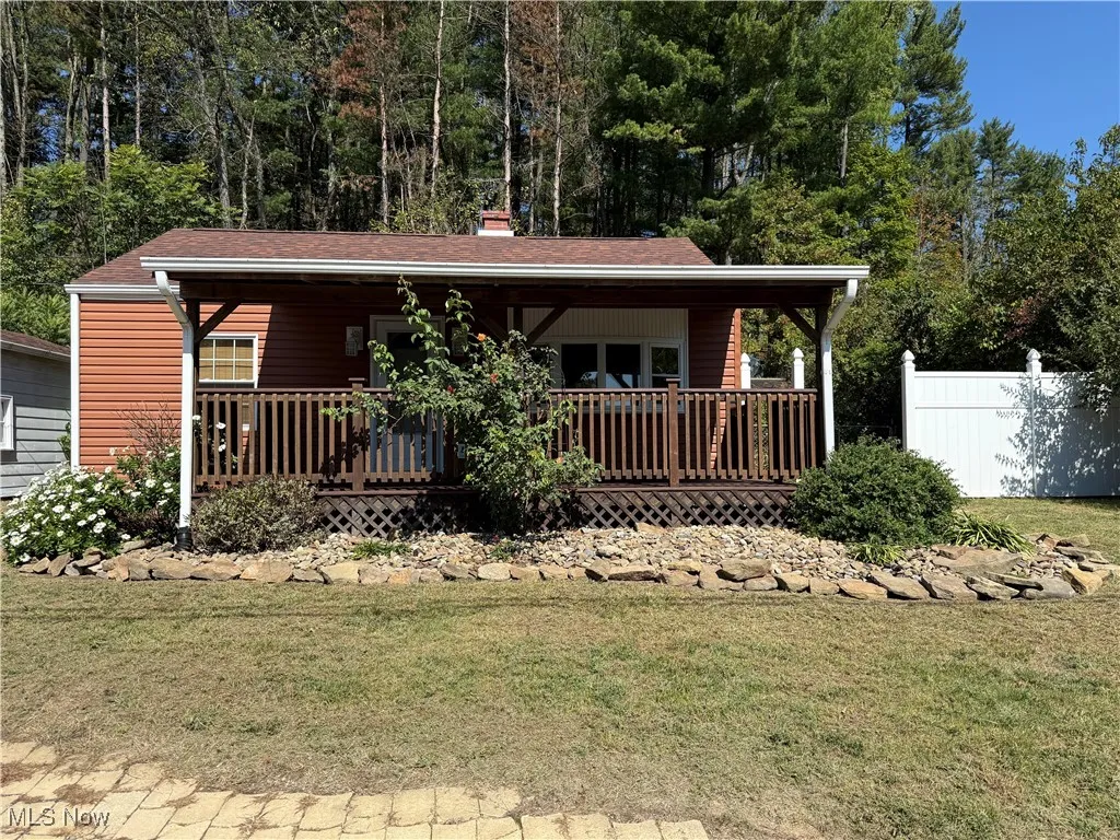 View of front of home featuring a chimney and covered porch