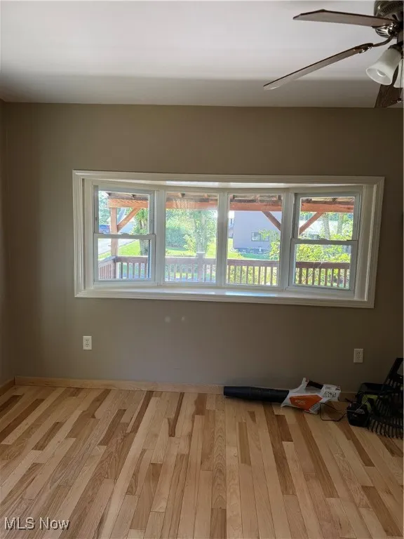 Spare room with wood finished floors and a ceiling fan