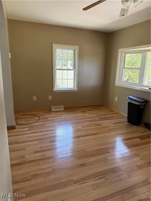 Unfurnished room with light wood-type flooring and a ceiling fan