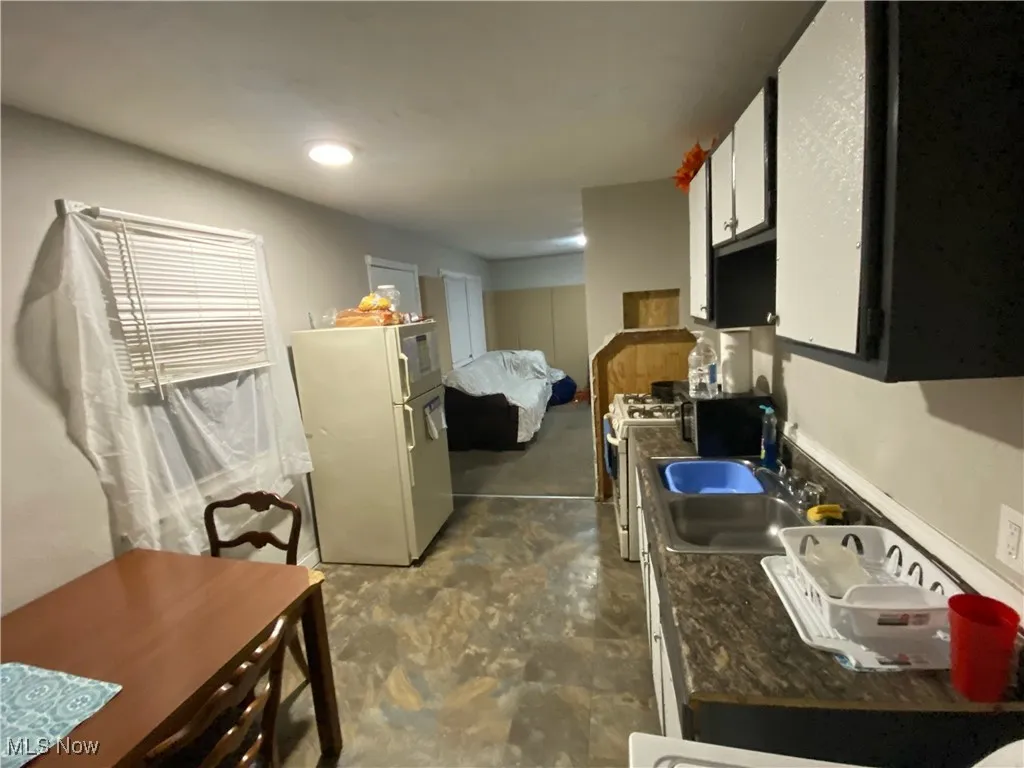 Eat-in Kitchen featuring white cabinetry, white appliances, and dark countertops