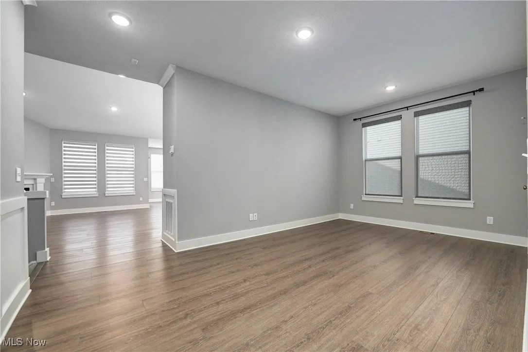 Spare room featuring dark wood-type flooring, a fireplace, and recessed lighting
