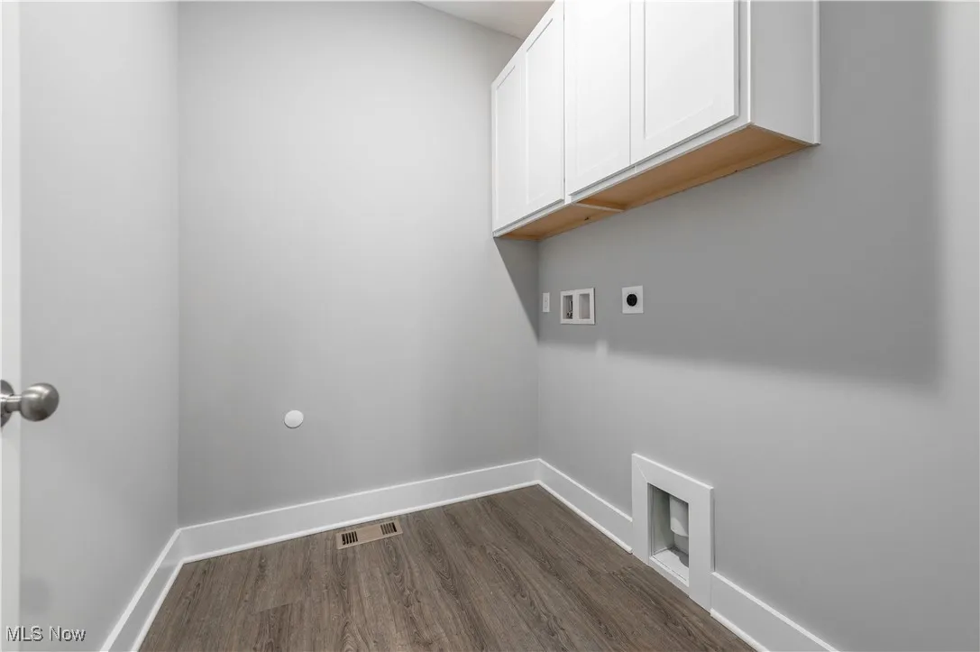 Laundry room featuring cabinet space, dark wood-style floors, hookup for a washing machine, and electric dryer hookup