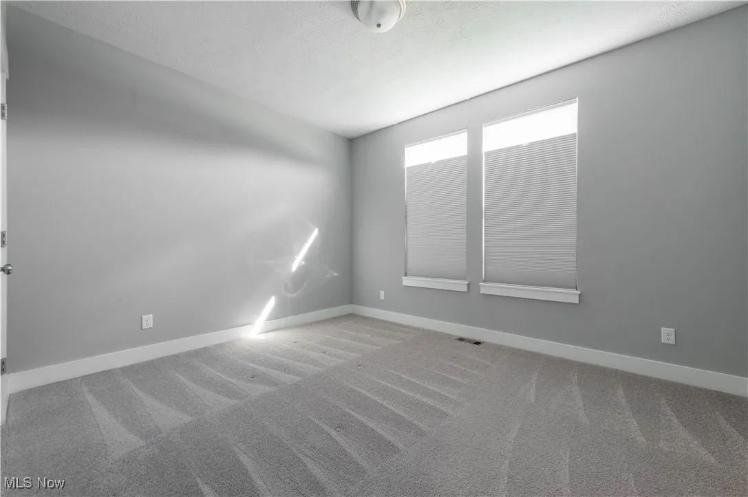 Spare room featuring carpet flooring and a textured ceiling