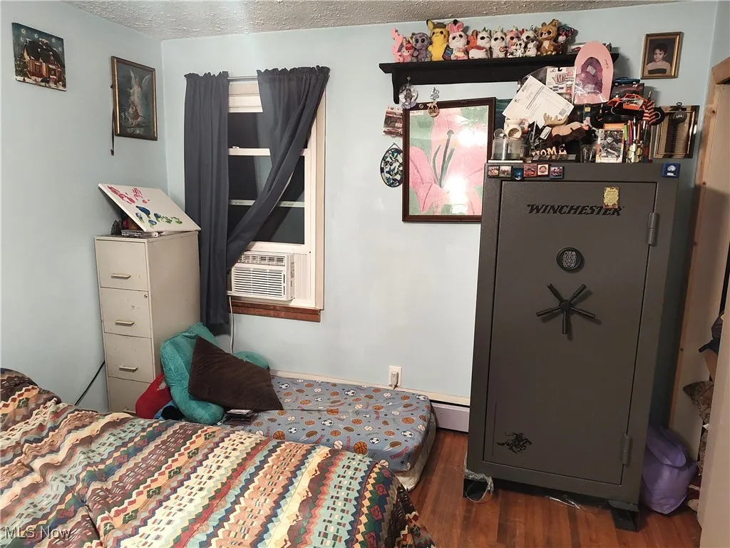 Bedroom featuring a textured ceiling and dark wood-style​​‌​​​​‌​​‌‌​‌‌​​​‌‌​‌​‌​‌​​​‌​​ floors