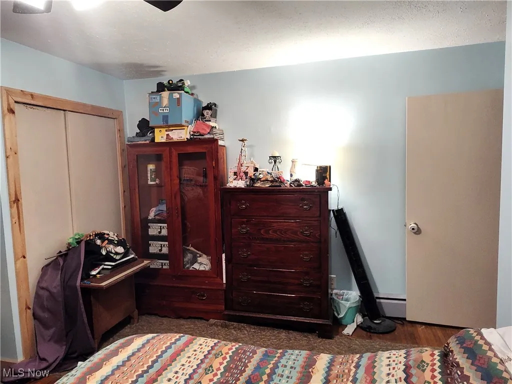 Bedroom with a textured ceiling and ceiling fan