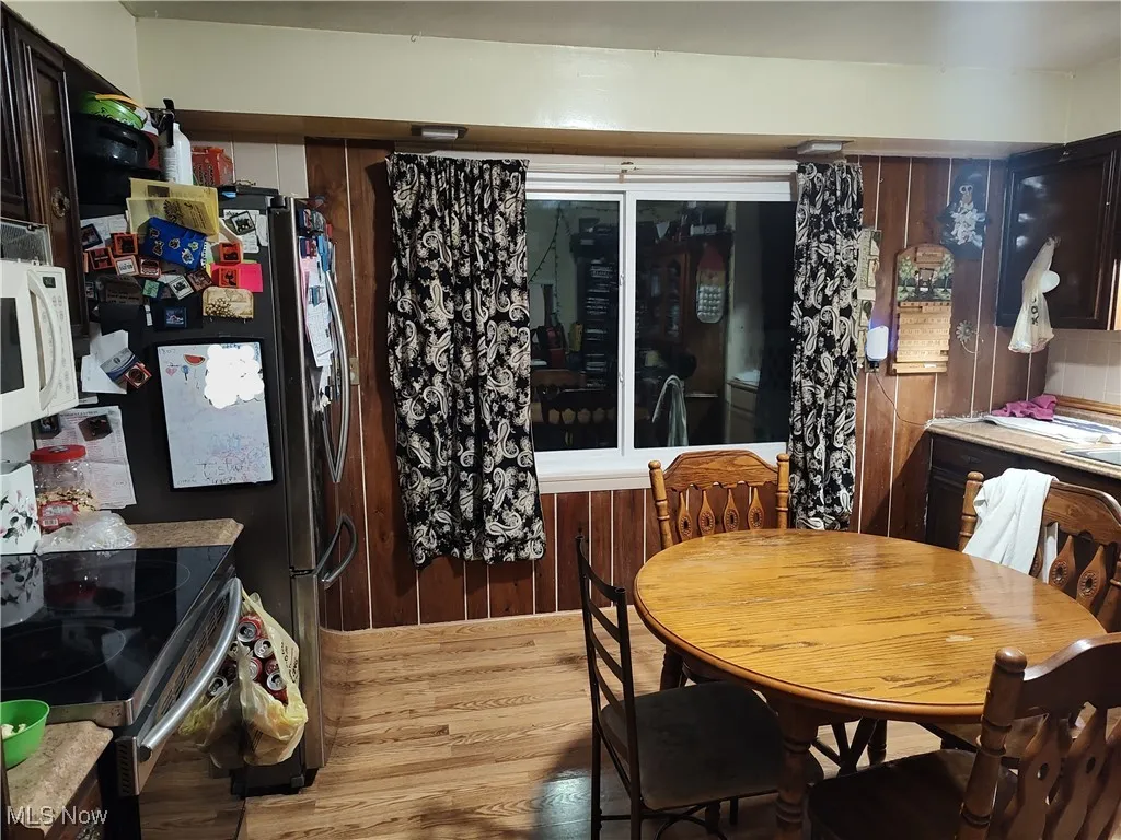 Dining area with wood finished floors and wood walls