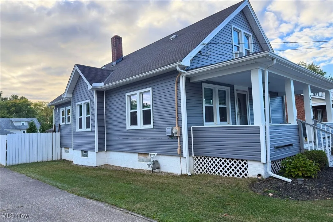 View of home's exterior with covered porch and a chimney