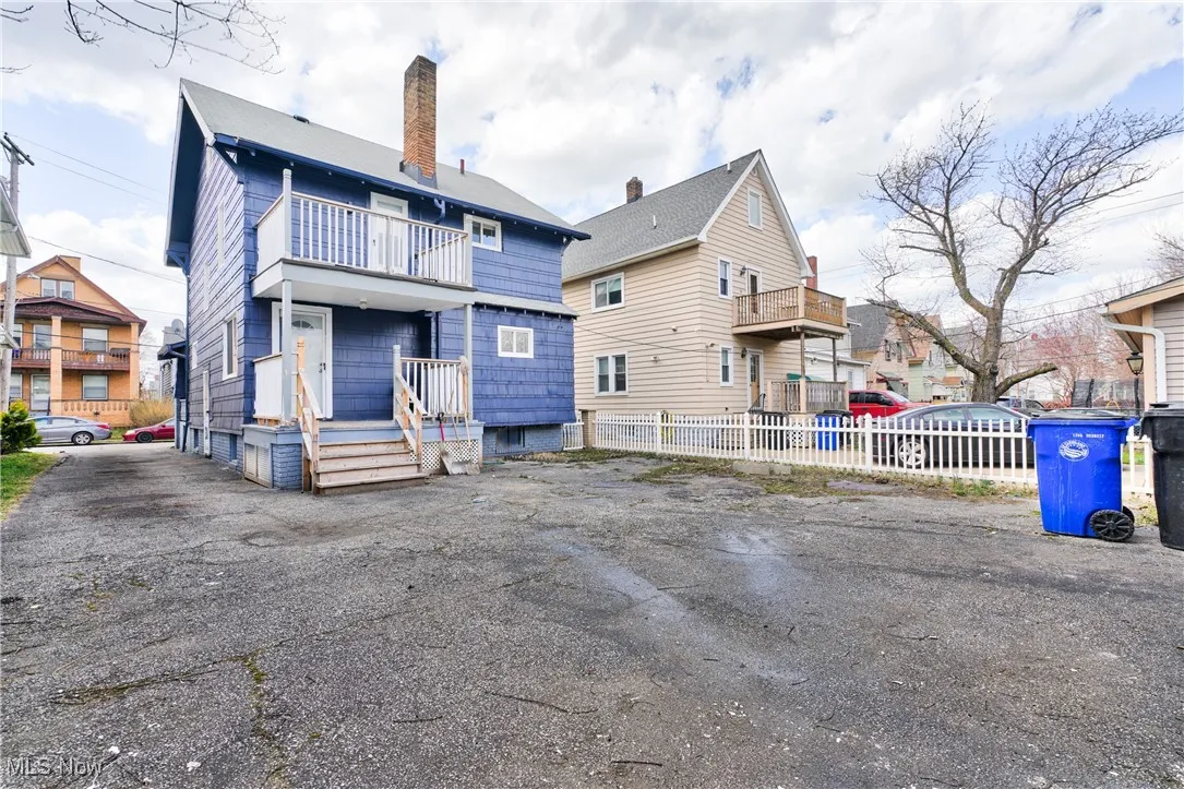 Back of property with a balcony, a residential view, and a chimney