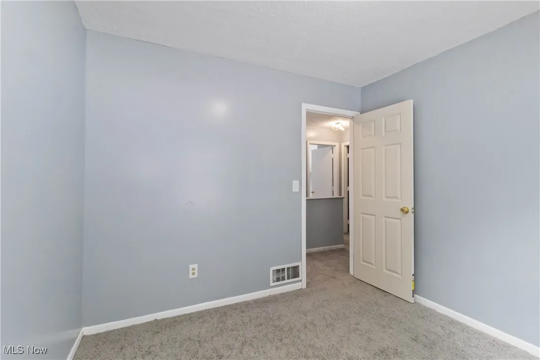Spare room featuring baseboards and light colored carpet