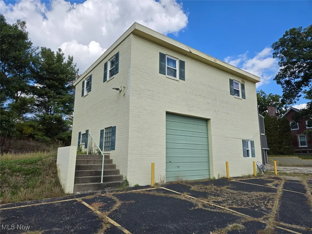 View of side of property featuring brick siding and stairs