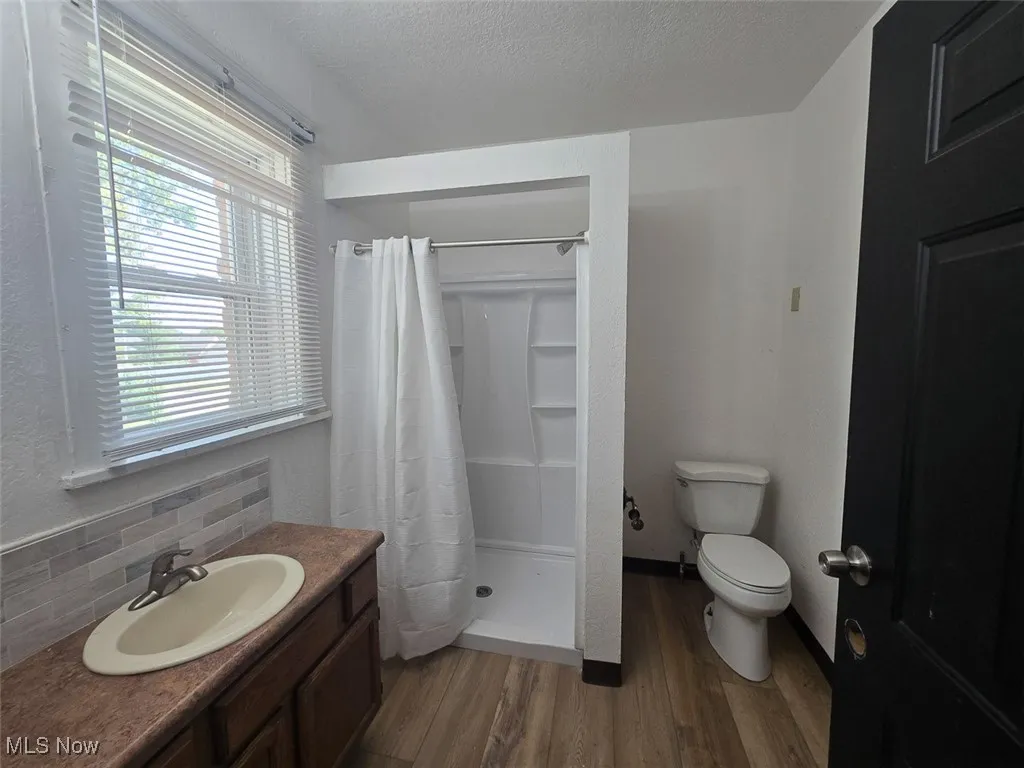 Bathroom with a shower stall, dark wood-type flooring, vanity, and a textured ceiling