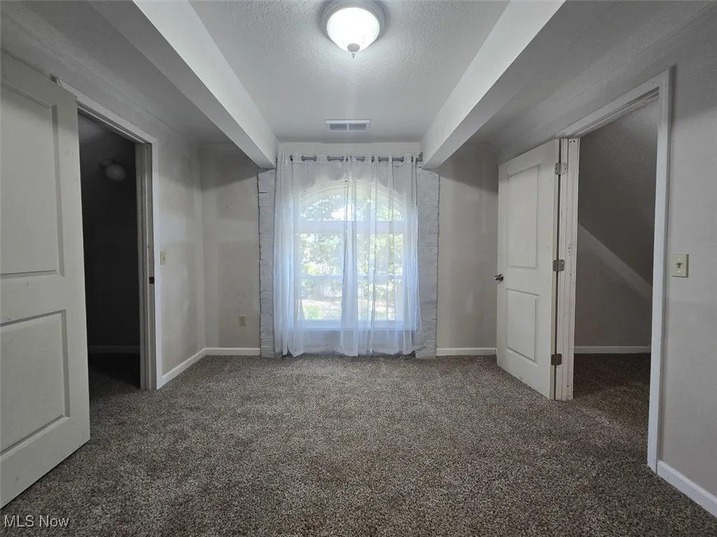 Unfurnished bedroom featuring a textured ceiling and carpet floors
