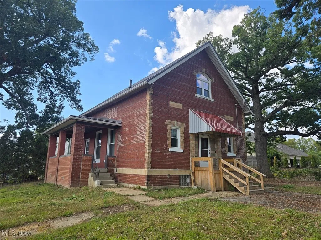 View of side of property with brick siding and a yard