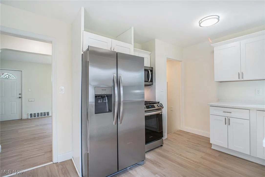 Kitchen featuring stainless steel appliances, white cabinetry, and light wood-type flooring
