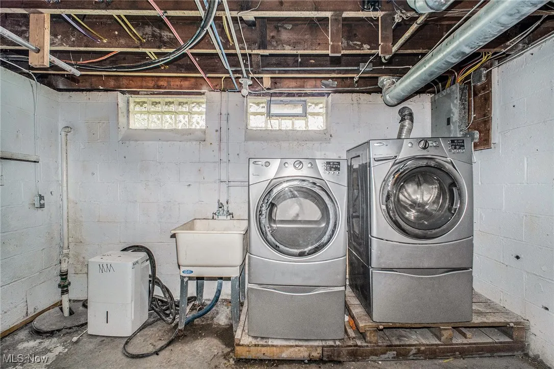 Laundry room with concrete floors and washer and clothes dryer