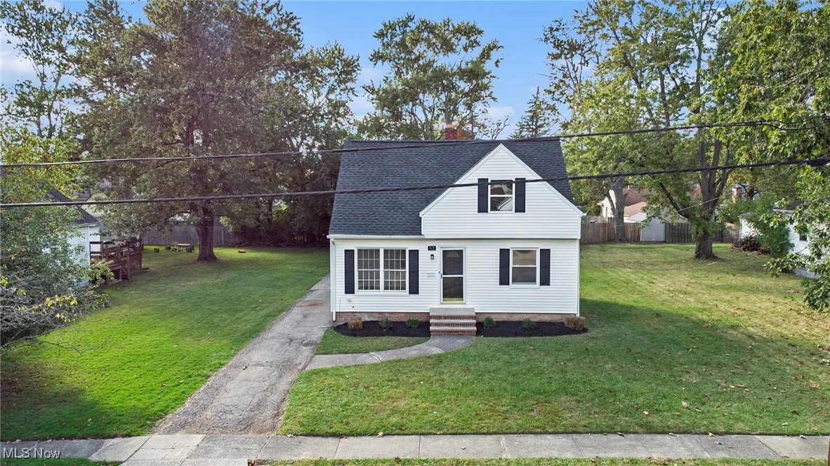 View of front of house featuring a chimney, a front yard, a shingled roof, and entry steps