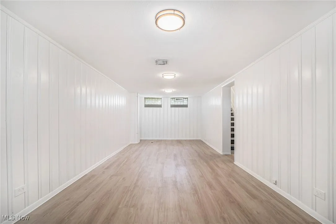 Spare room with light wood-style floors and crown molding