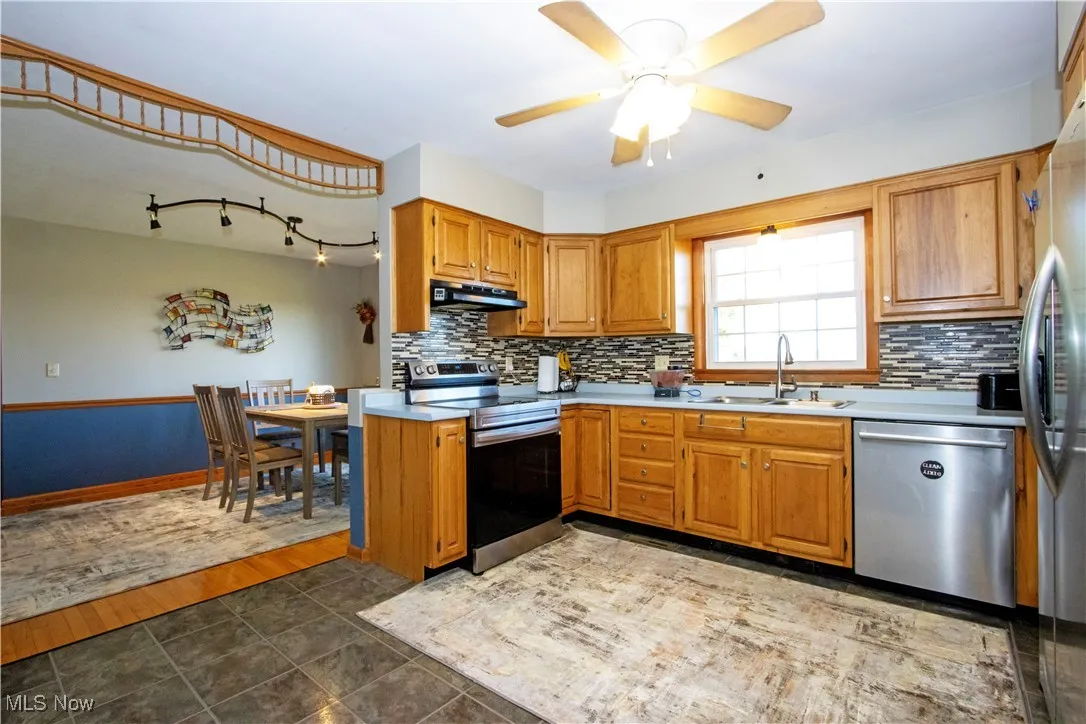 Kitchen featuring stainless steel appliances, brown cabinets, and light countertops