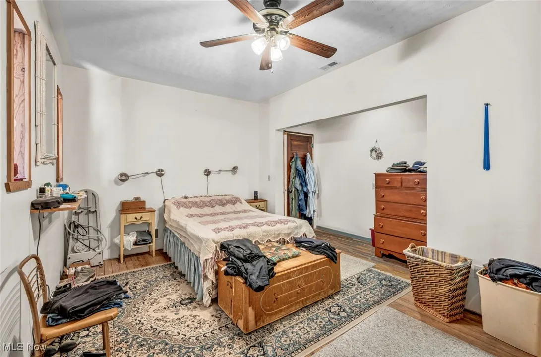 Primary bedroom with hardwood floors /  connecting closets to the first bedroom & a hallway to lead to the dining room & bathroom