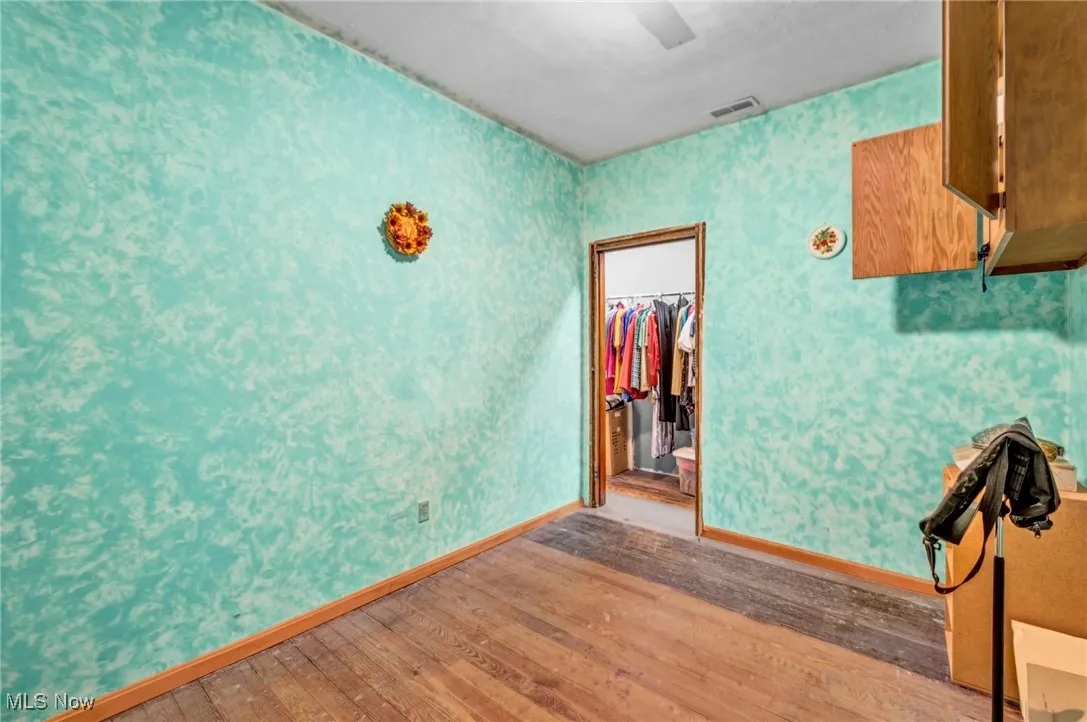 First bedroom to the right walking down the hallway. Hardwood floors / connecting closets / painted walls