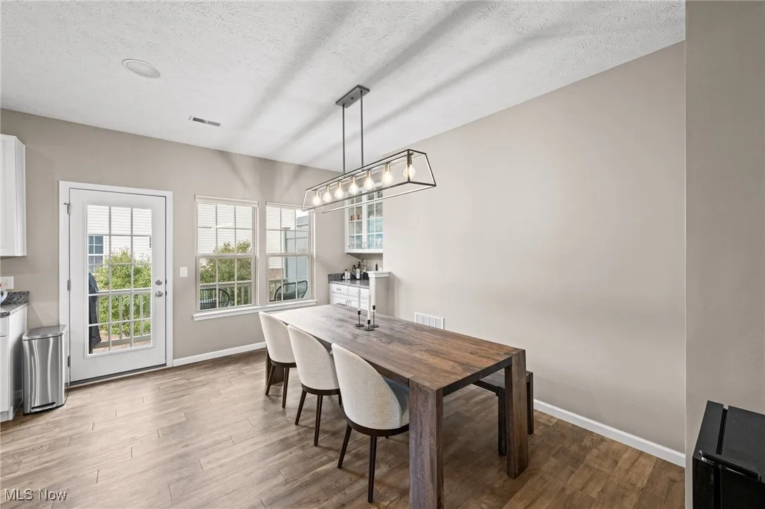 Dining area with a textured ceiling and wood finished floors