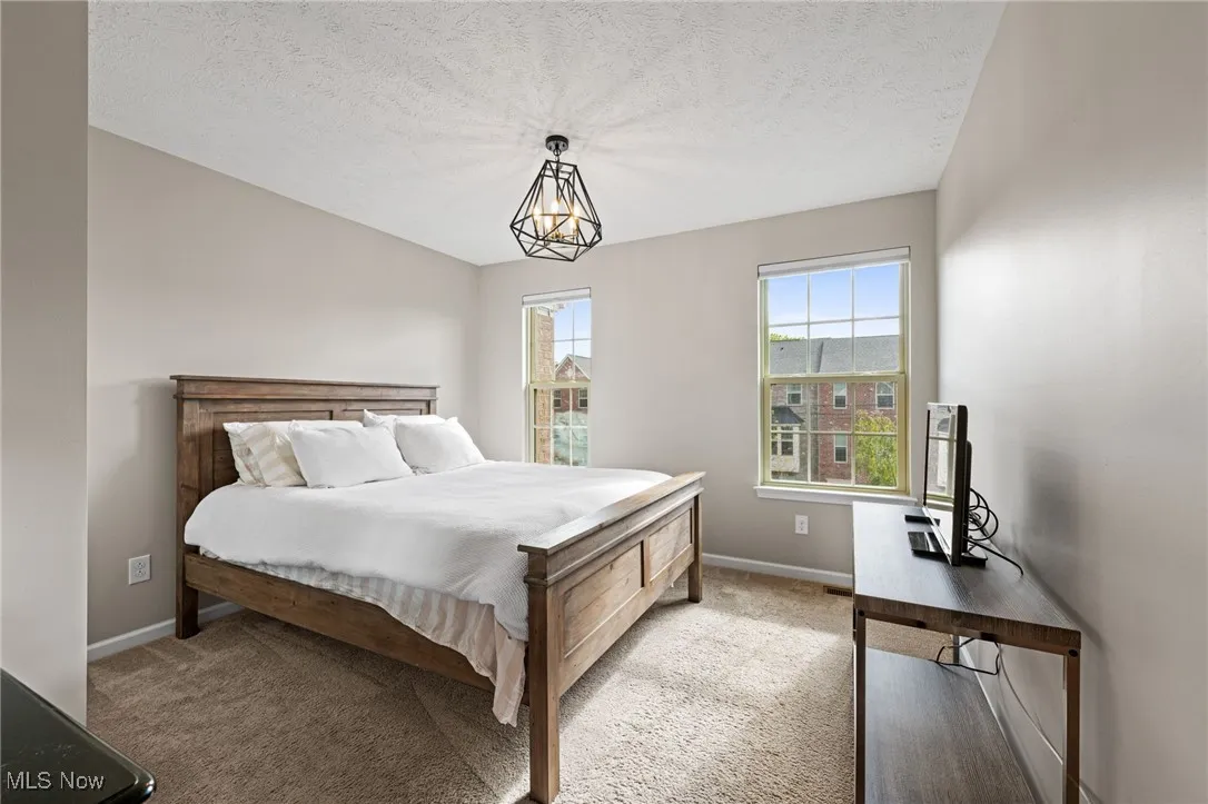 Bedroom featuring a textured ceiling and light colored carpet