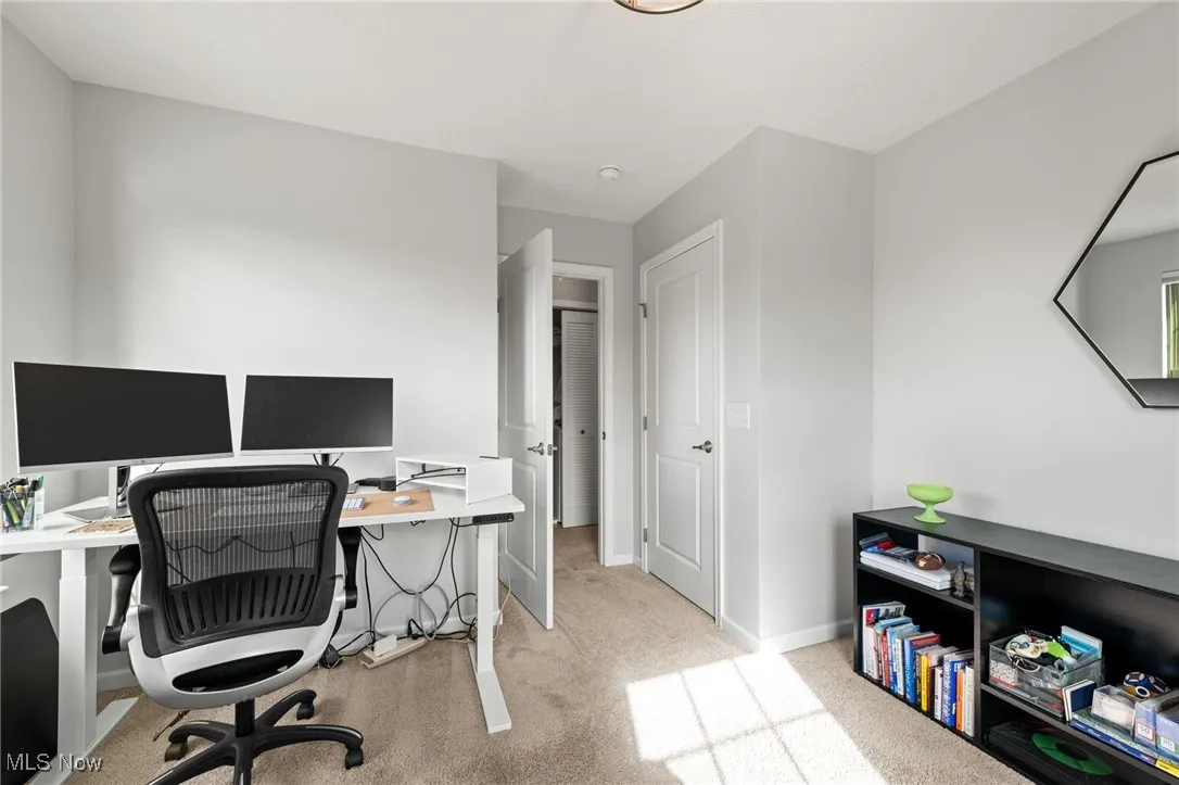 Bedroom with light colored carpet and baseboards