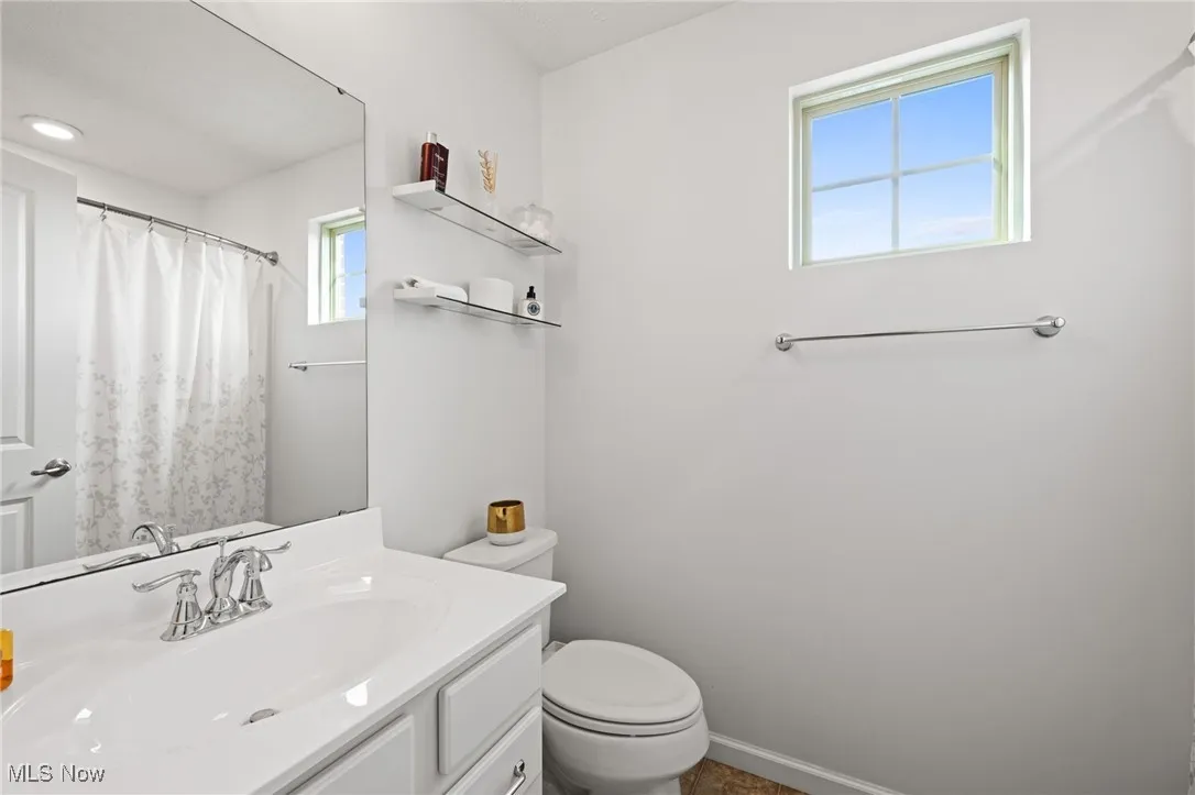 Full bathroom with vanity and curtained shower