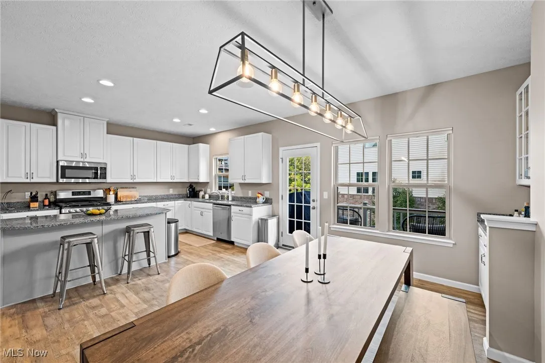 Dining area with healthy amount of natural light, light wood-style flooring, recessed lighting, and a textured ceiling