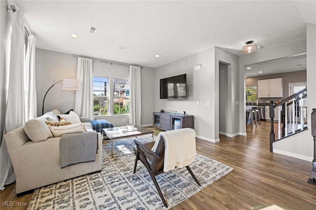 Living room with wood-style flooring, healthy amount of natural light, and recessed lighting