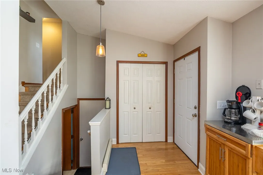 Foyer featuring light wood-style flooring, a baseboard heating unit, and stairway