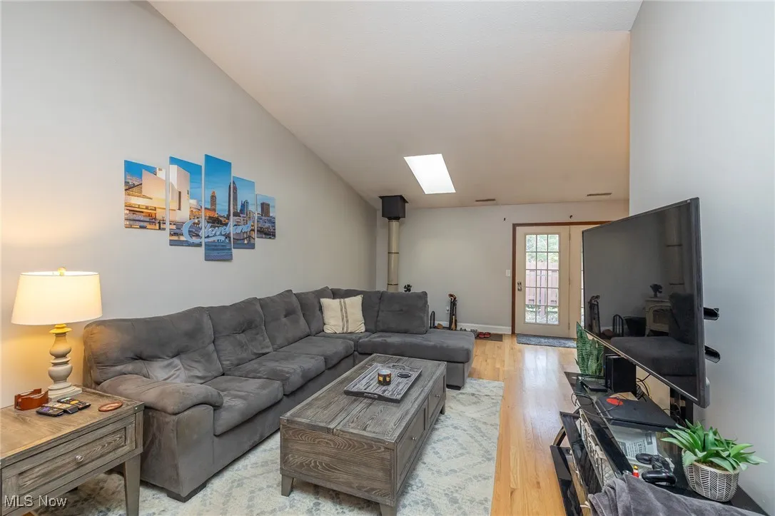 Living room with a skylight and light wood-type flooring