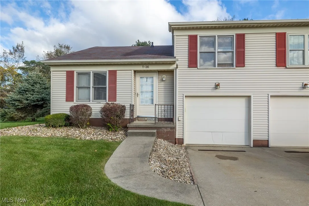 Tri-level home featuring a front yard, a garage, and driveway