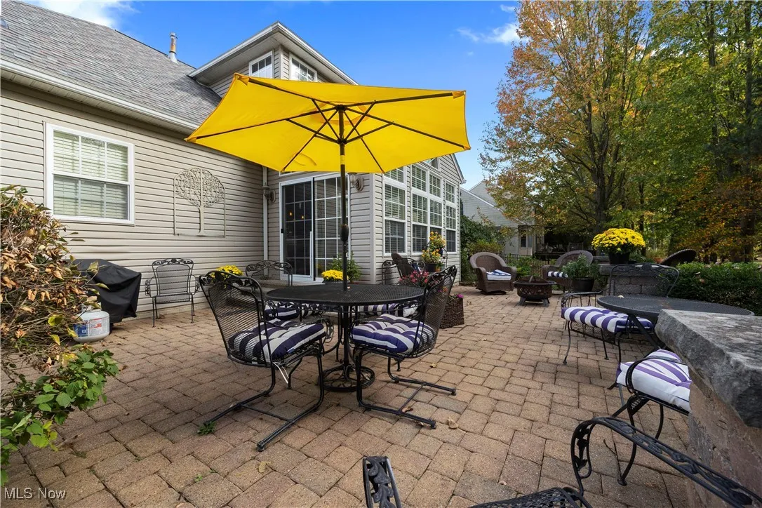 View of patio with outdoor dining space and a grill