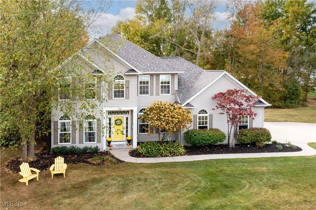Colonial house with a front lawn and a shingled roof