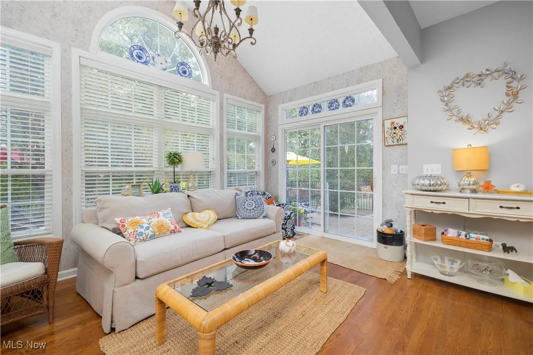 Sunroom with lofted ceiling, healthy amount of natural light, and a chandelier