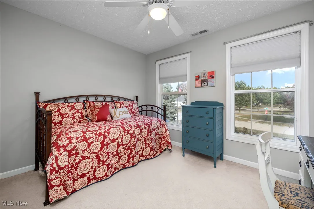 Bedroom with carpet, a textured ceiling, and ceiling fan