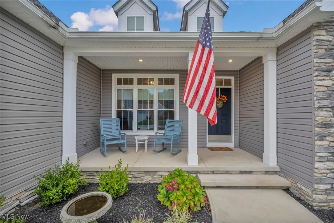 Entrance to property featuring a porch and stone siding