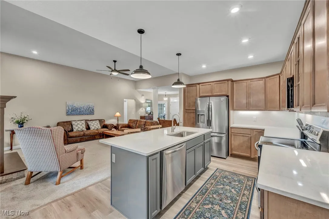 Kitchen featuring stainless steel appliances, light wood-type flooring, hanging light fixtures, a ceiling fan, and recessed lighting