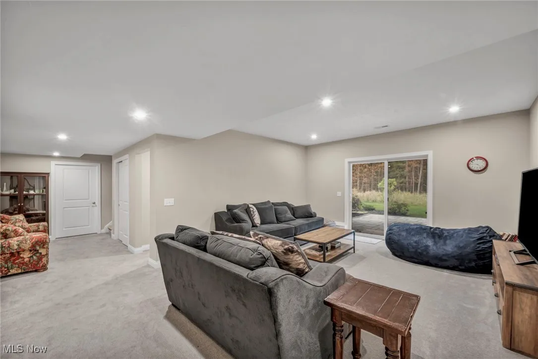 Living area featuring light colored carpet and recessed lighting