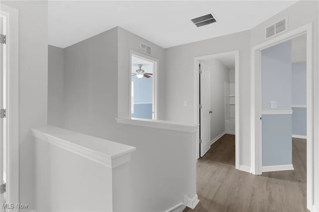 Corridor with an upstairs landing and wood finished floors