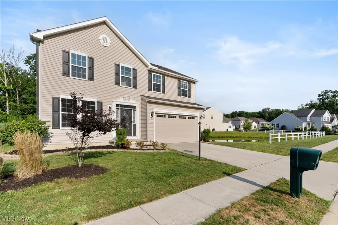 View of front facade featuring driveway, an attached garage, and a residential view