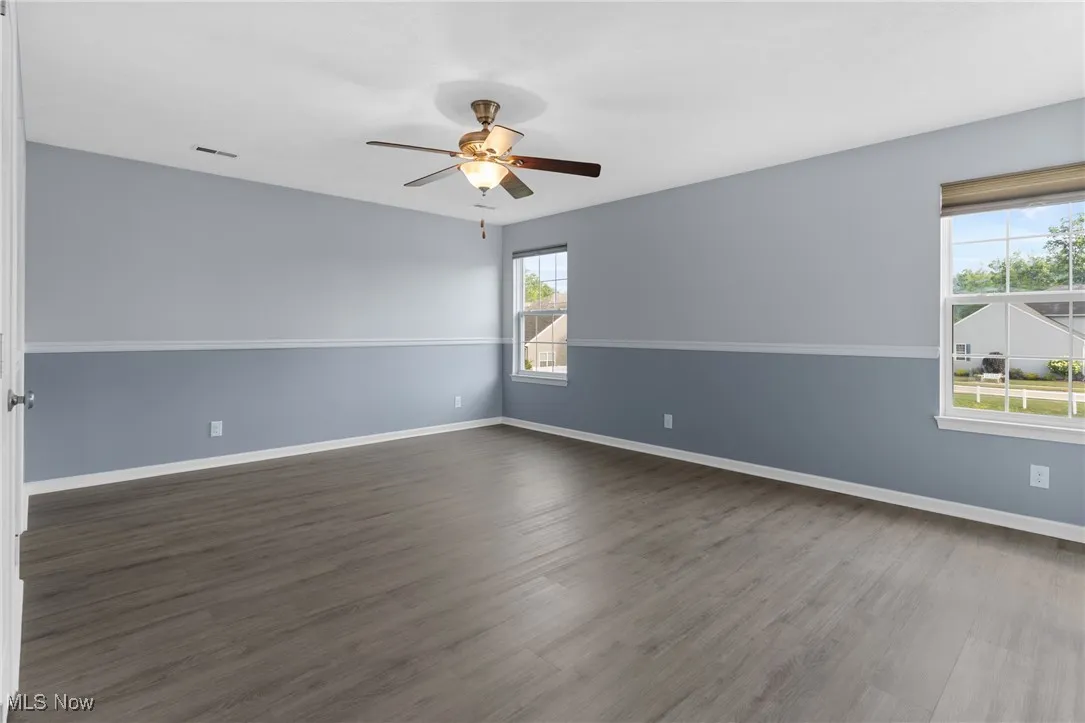 Spare room with dark wood-style flooring and ceiling fan