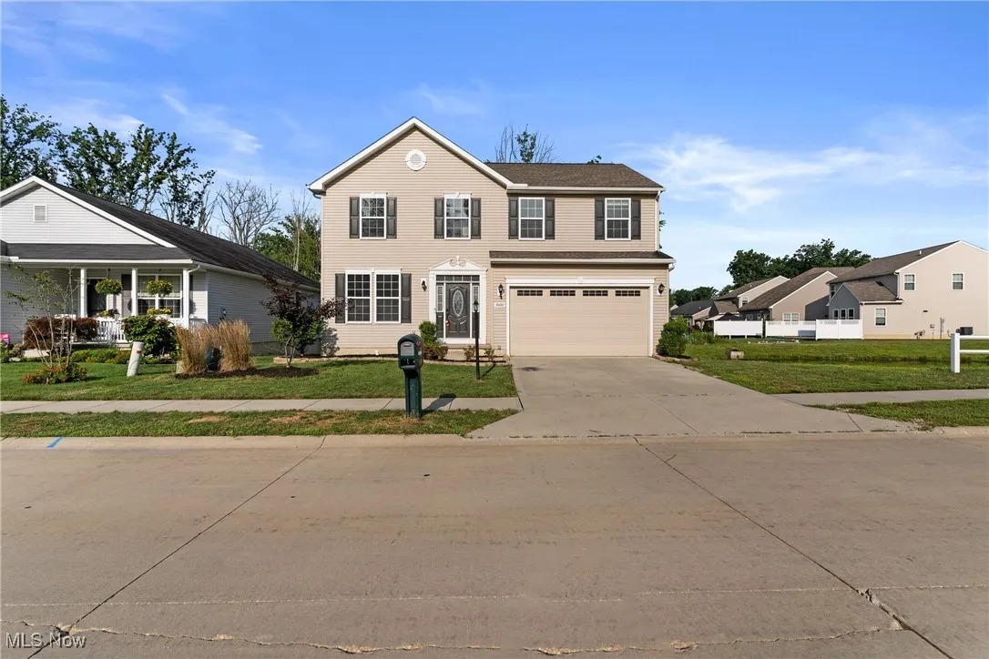 Traditional home with a front yard, driveway, and a garage