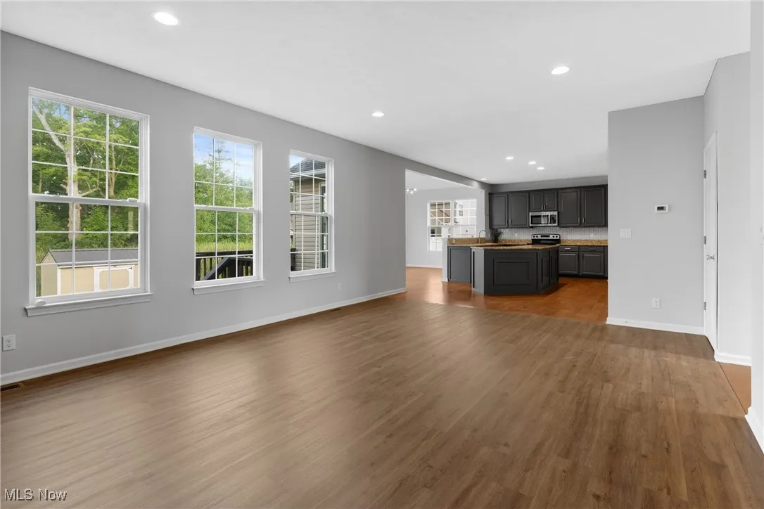 Unfurnished living room featuring recessed lighting and dark wood-style floors