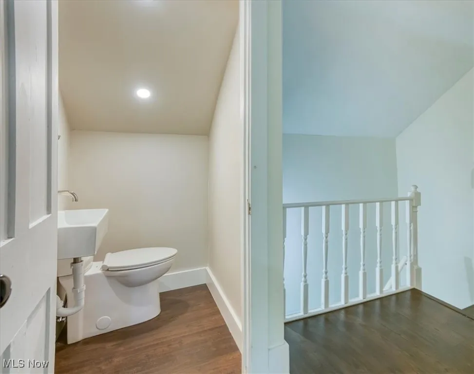 Half bathroom featuring dark wood-type flooring and recessed lighting