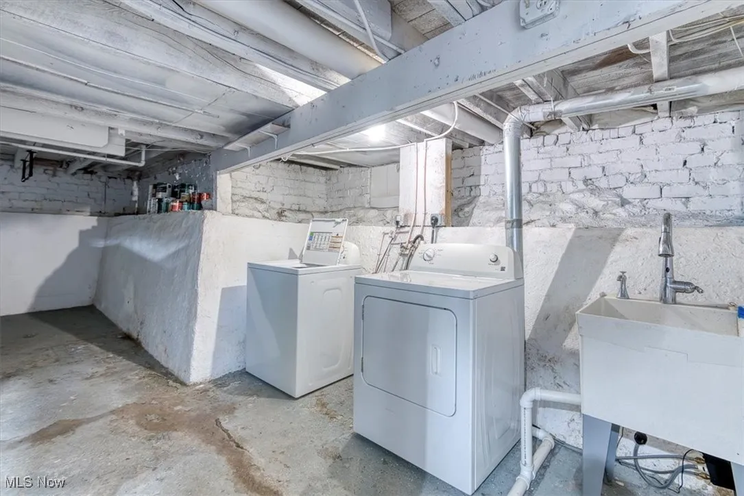 Laundry area featuring unfinished concrete flooring and washing machine and clothes dryer