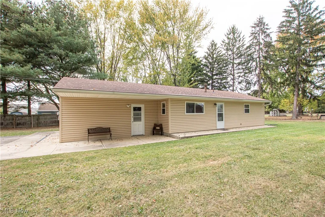 Back of property with a patio area and roof with shingles